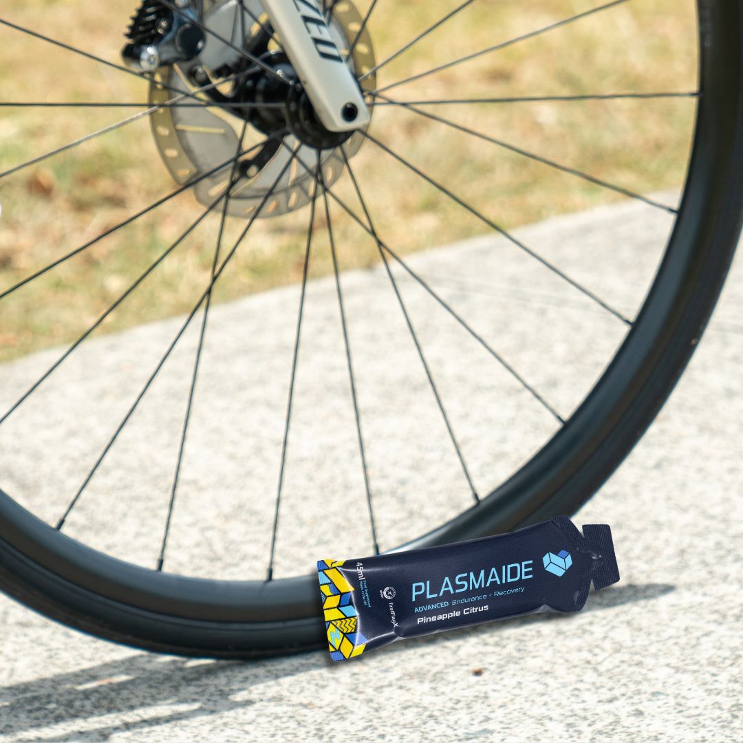 Single-serve Plasmaide Pineapple Citrus beverage in a clear glass, showcasing vibrant yellow-orange liquid with citrus slices.