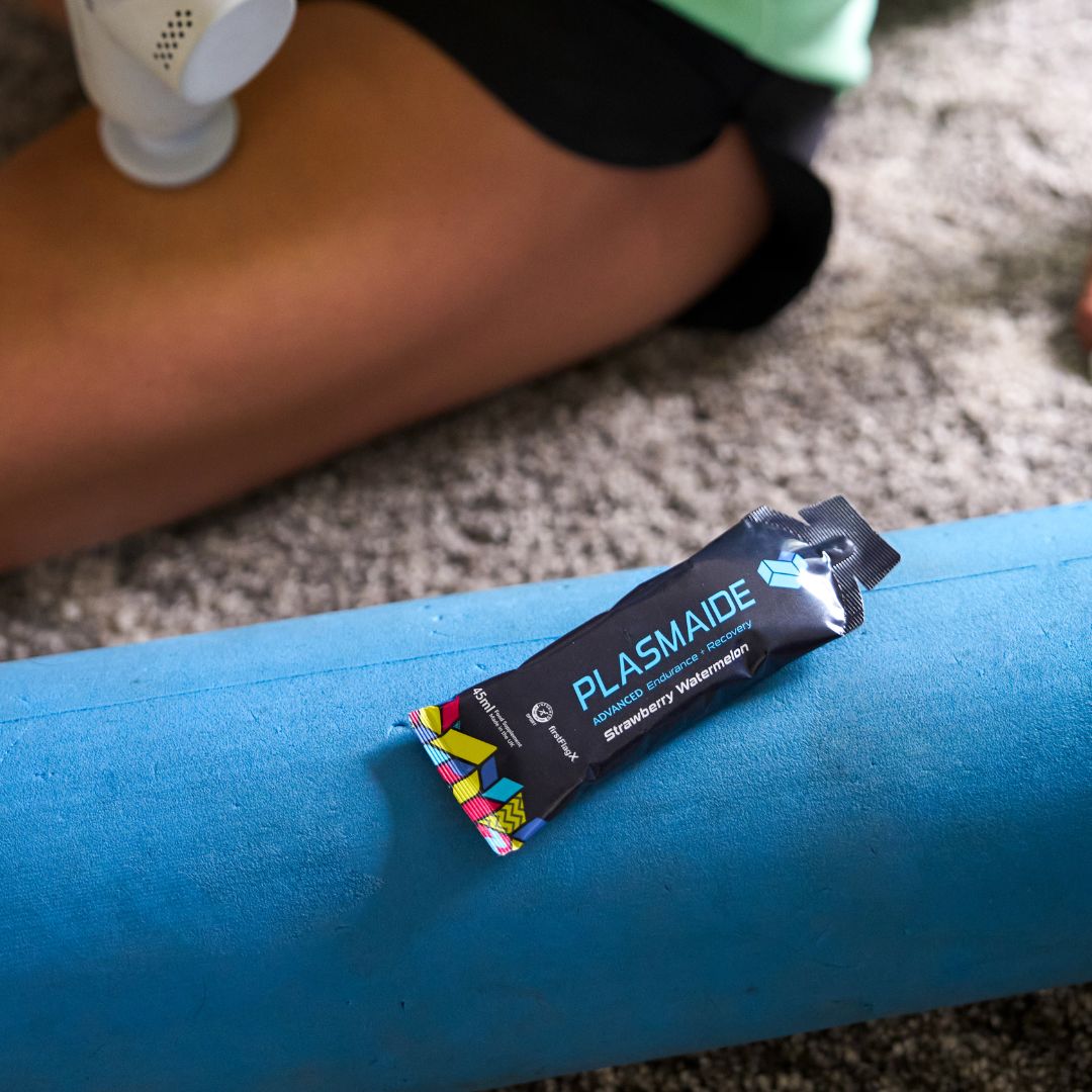 Single-serve Plasmaide Strawberry Watermelon flavored drink in a clear plastic cup with vibrant red and green fruit slices.